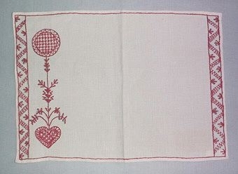 Tablett broderad i Hallandssöm. Broderad på halvblekt linne med rött bomullsgarn. Mönstret består av två bårder, hjärta mm.