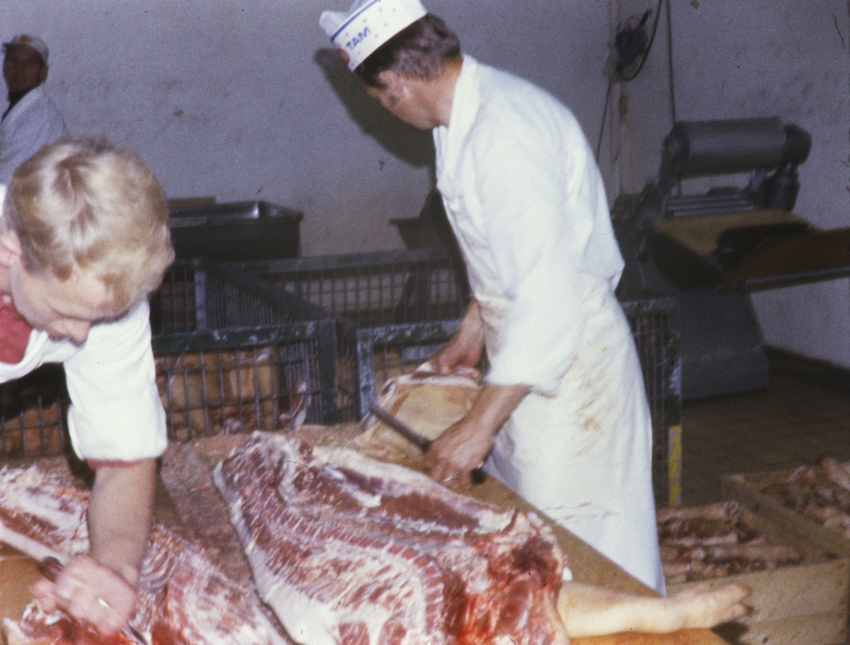 Bothnerarbeidere skjærer kjøtt inne på fabrikken i Havnegata.