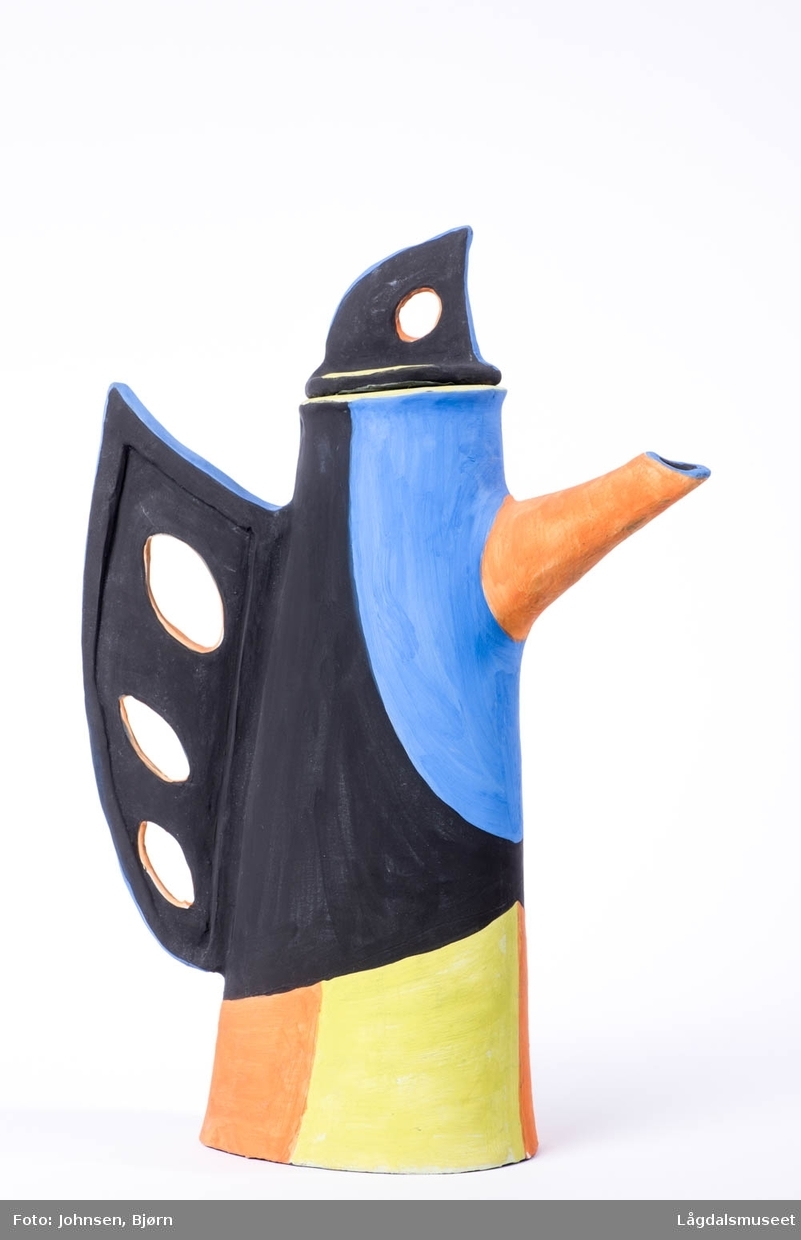 Kannen har en utforming som kan minne om en stilisert fugl. Utført i uglasert leire.