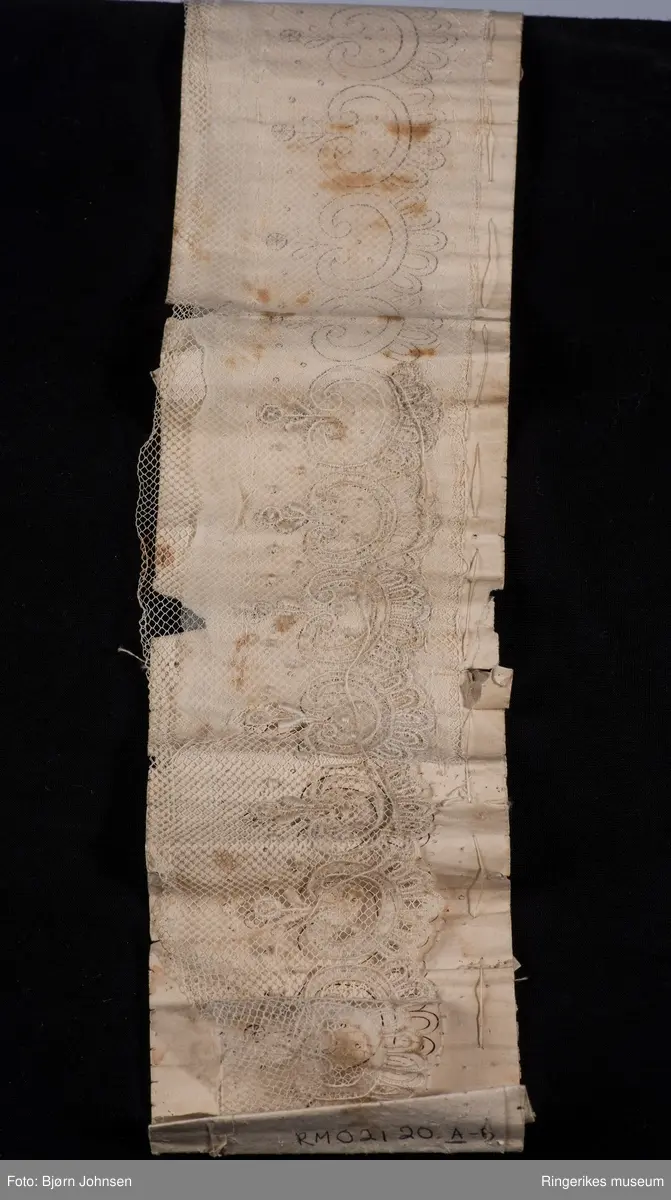 stiliserte blomster på en remse med en tungekant.  PÅ B - lokk: avbildet kvinne pyntet med blomster, perler  og en tett kant av blonder rundt halsen.