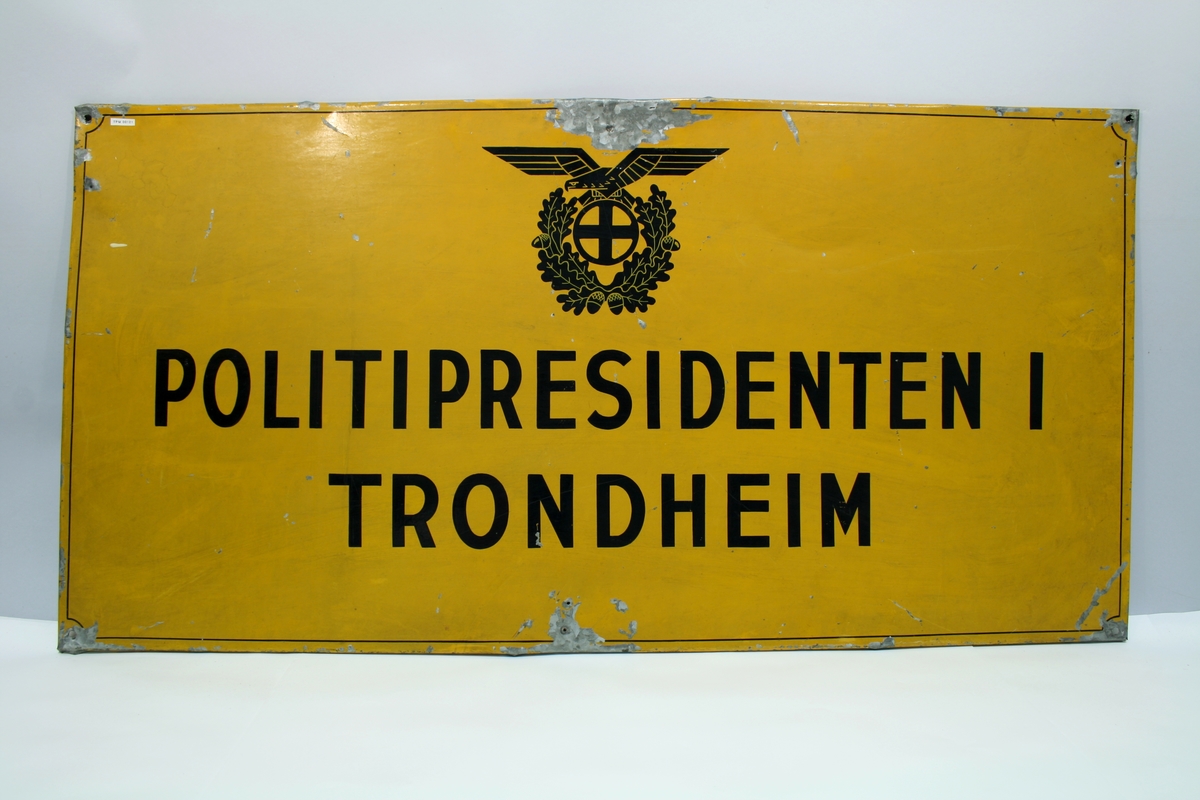 Det norske nazifiserte politimerke med ørn (skarven) over solkors og ekeløvkrans.