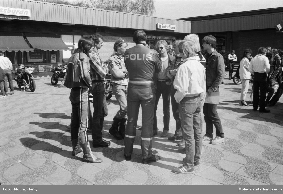 Kållereds Motorklubb visar upp motorcyklar i Kållereds centrum, år 1984. MC-polis Lennart Johansson samtalar med en samling killar.

För mer information om bilden se under tilläggsinformation.
