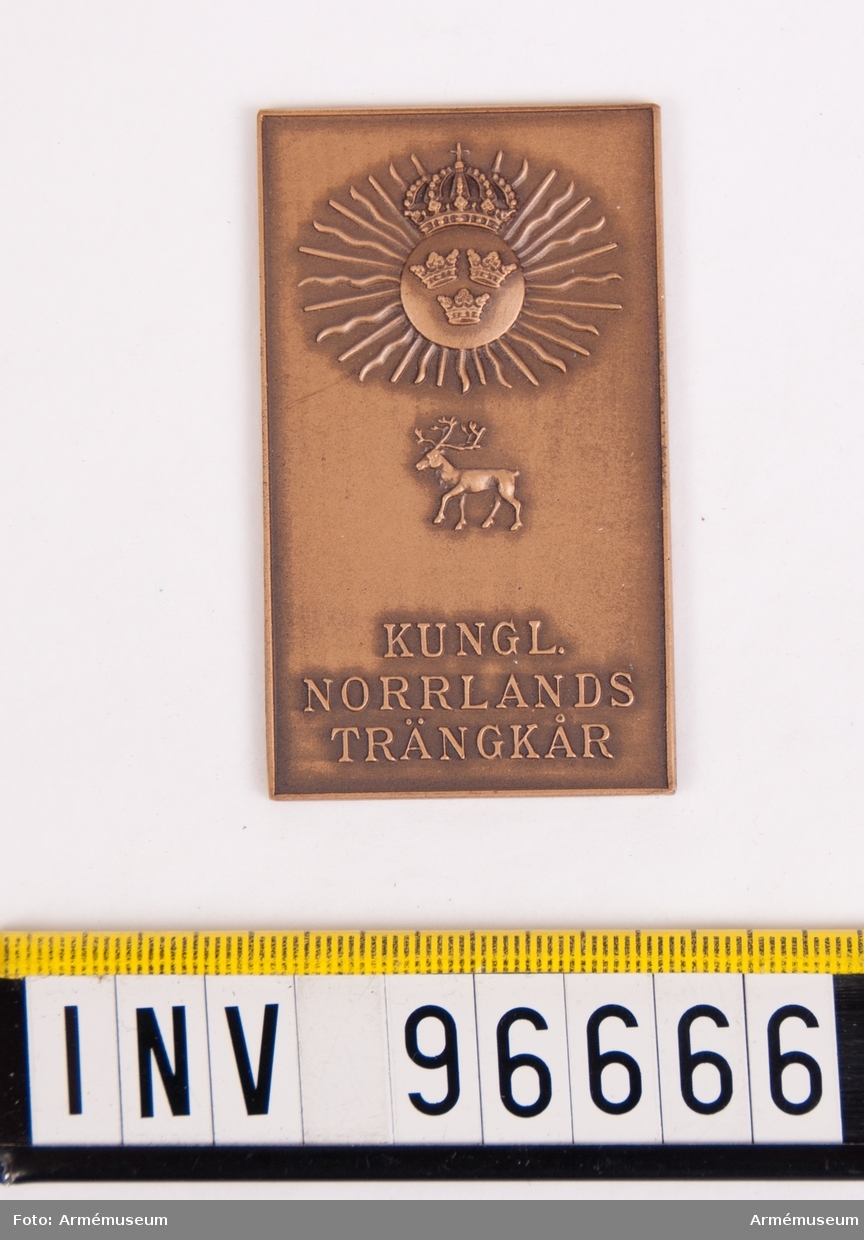 Plakett i brons för Norrlands trängkår.
Stans nr 19922, härdad 1948-08-14.
Plakett, 37x63 mm, åtsida m. kårens vapen, 3-kronor på rund sköld, krönt av kunglig krona, jämte strålar samt därunder ren, nedtill inskription KUNGL. NORRLANDS TRÄNKÅR, plaketten omgiven av upphöjd kant.