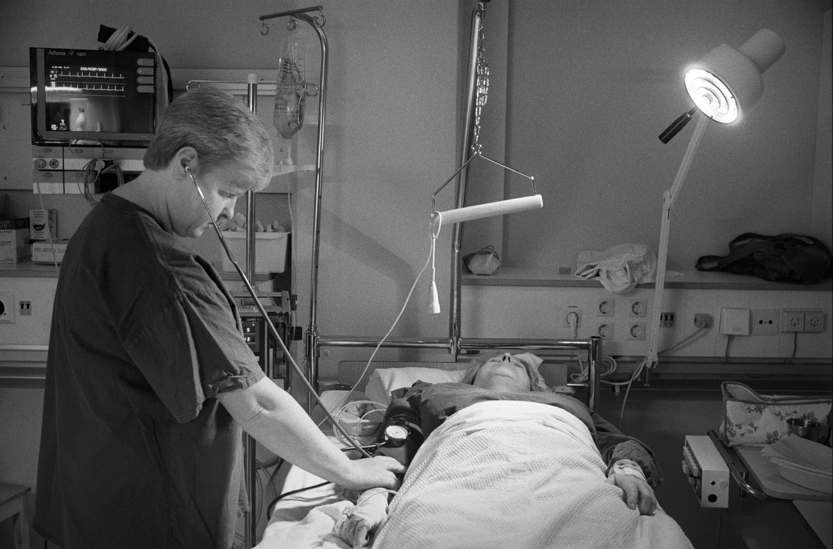 Sjuksköterska tar blodtrycket på patient som ligger på "uppvaket", Samariterhemmets sjukhus, Uppsala 1991