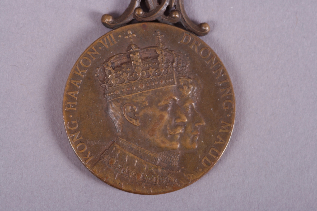 På medaljens forside er det portrett av Kong Haakon VII og Dronning Maud
På medaljens bakside teksten: Kroningen i Trondheim 22 de juni 1906. Alt for Norge.