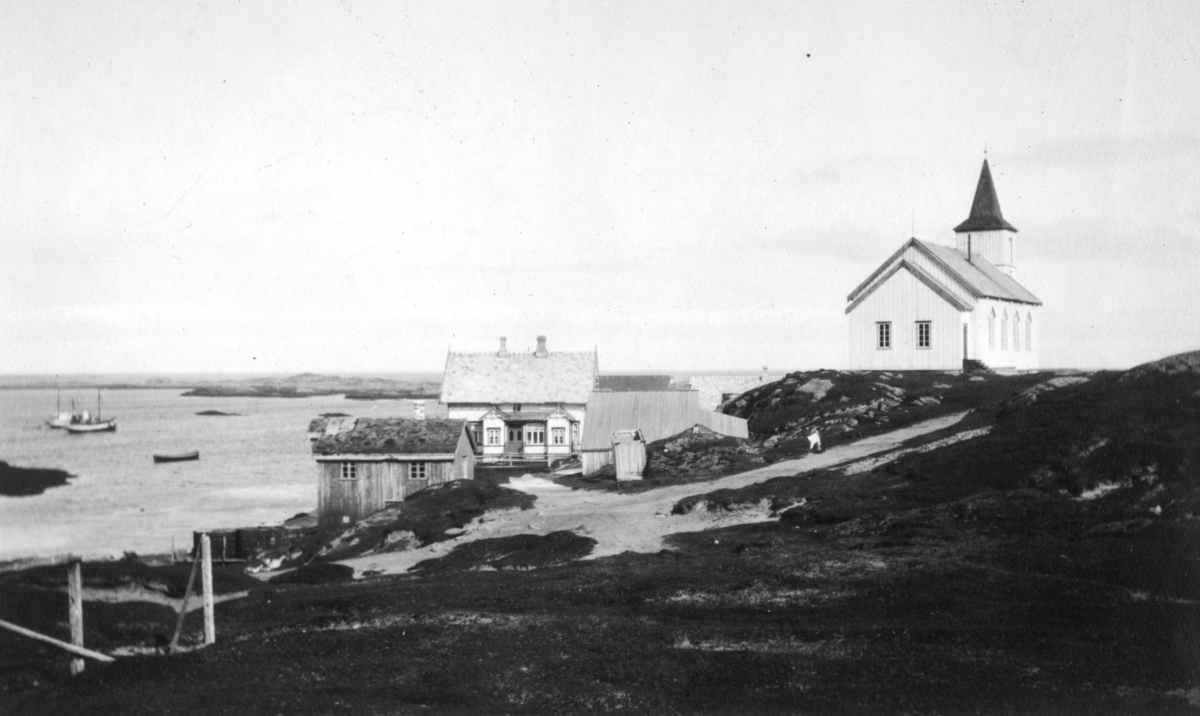 'Fra Ingøy - Norges ytterste skjær mot nord.' Vi ser kapellet på Ingøy, og et bolighus med sjøbod. Ute på sjøen ligger et par båter.