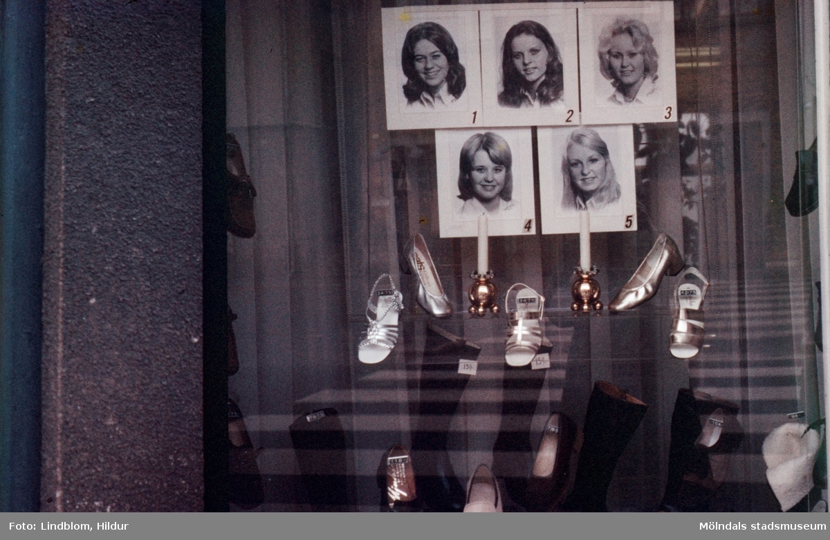 Porträtt av luciakandidater samt skor i skyltfönstret till Rasmussons skoaffär med adress Kvarnbygatan 4 vid Gamla Torget i Mölndal, 1970-tal. Affären var med och sponsrade luciatruppen.

För mer information om bilden se under tilläggsinformation.