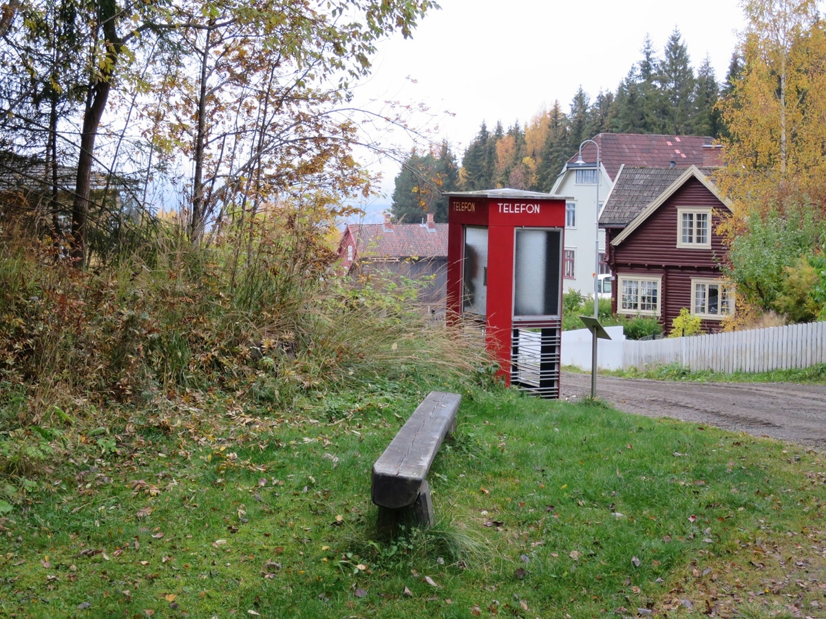 Denne telefonkiosken står på Maihaugen, Lillehammer, og er en av de 100 vernede telefonkioskene i Norge. De røde telefonkioskene ble laget av hovedverkstedet til Telenor (Telegrafverket, Televerket). Målene er så å si uforandret. 
Vi har dessverre ikke hatt kapasitet til å gjøre grundige mål av hver enkelt kiosk som er vernet. 
Blant annet er vekten og høyden på døra endret fra tegningene til hovedverkstedet fra 1933.
Målene fra 1933 var:
Høyde 2500 mm + sokkel på ca 70 mm
Grunnflate 1000x1000 mm.
Vekt 850 kg.
Mange av oss har minner knyttet til den lille røde bygningen. Historien om telefonkiosken er på mange måter historien om oss.  Derfor ble 100 av de røde telefonkioskene rundt om i landet vernet i 1997. Dette er en av dem.
