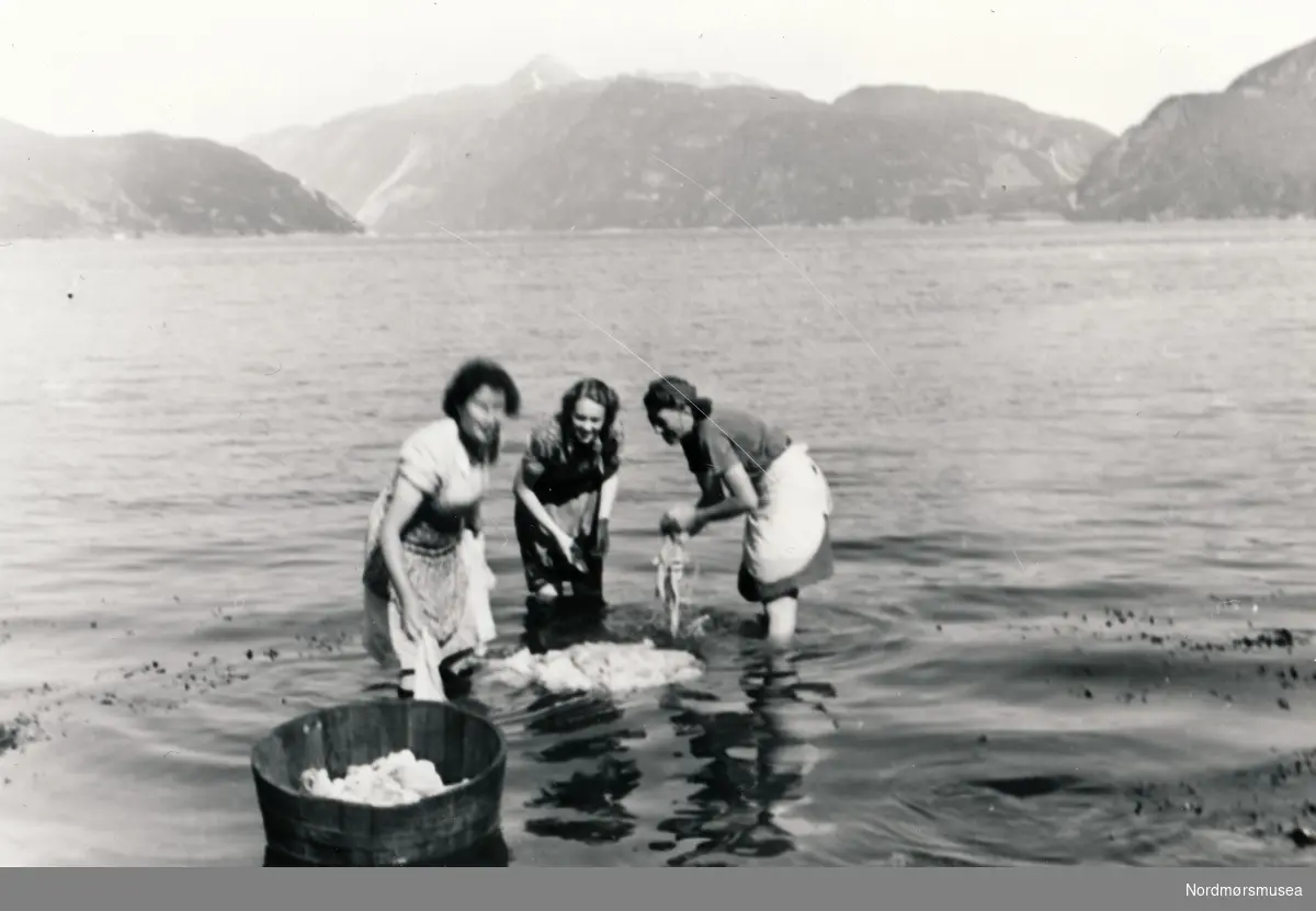 Tre kvinner som vasker klær i Sunndalsfjorden.