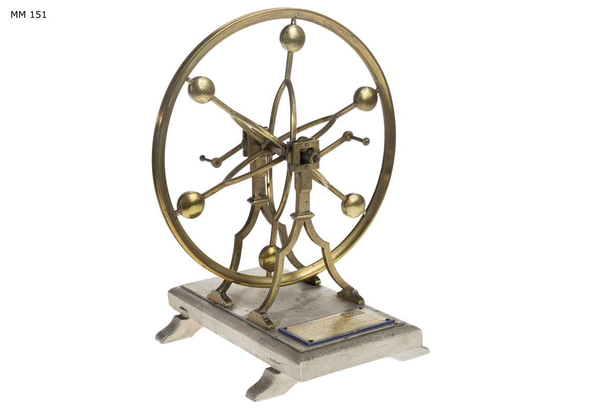 Modell av uppfordringshjul på ställning med rullager och tyngder som drivs med vevar. Allt av mässing, Ställningen är fastsatt på gråmålad träplatta.

Tolkning:
Är en experimentmodell, troligen avsedd att visa hur ett hjul med rullager kan drivas utan alltför stort motstånd.
Ingår i modellkammarens inventarium 1804 och 1834. Beskrivningen i 1834 års inventarium är:
Uppfordrings hjul af Messing. Inköpt 1801 från överstelöjtnant Frans Sheldon.
Se vidare Mikael Lindgrens artikel i Utställningskatalogen Modelkammaren 250 år