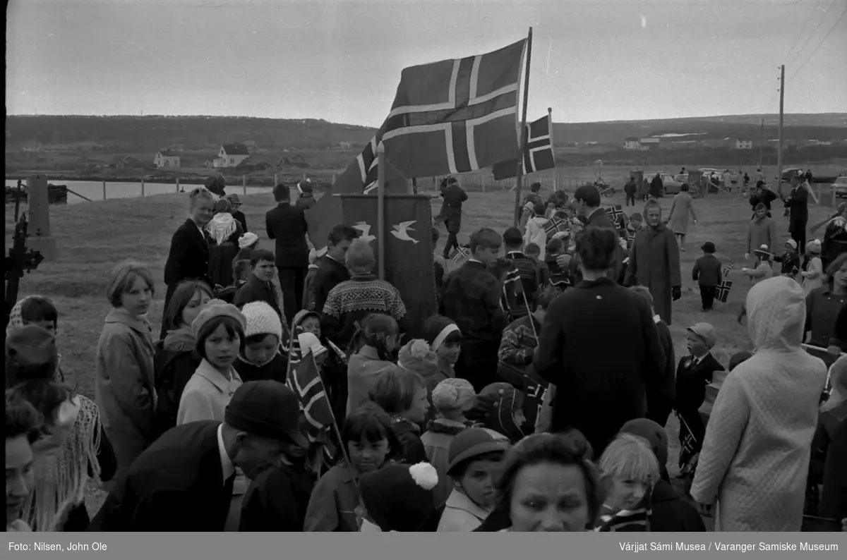 17. mai feiring utenfor Nesseby kirke i 1967.Toget gjør seg klart til å gå opp mot Nesseby skole. Fra venstre: Nils Anders, Ruth, Synnøve, Astrid og Ellinor Nilsen, Grethe Store, Kurt Johnsen og Kjell Andersen.