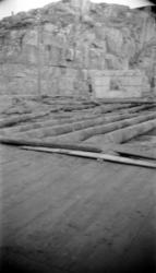 Stokkverk til  underlag hørende ei brygge under riving.  Tuf