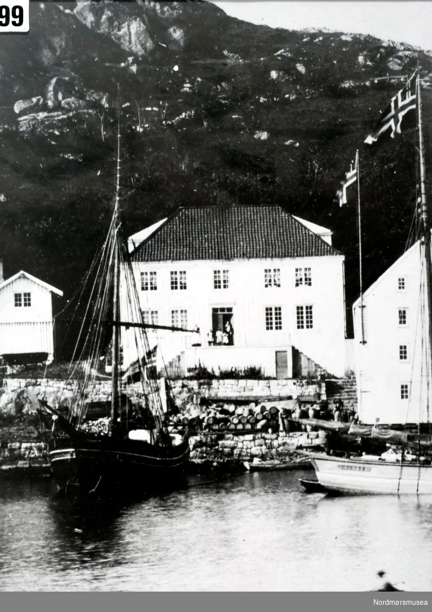 Ellingseneiendommen på Innlandet i Kristiansund omkring 1900, med en jakt liggende fortøyd like ved. Legg merke til de to norske flaggene som vaier i vinden. Fra Nordmøre Museums fotosamlinger. 
