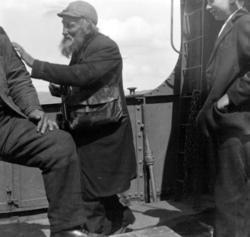 Foto av tre personer på et båtdekk. En ungdom, en middelaldr