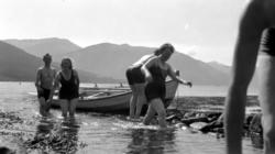 Fotografi av menn og kvinner som går i land etter bading. Ma