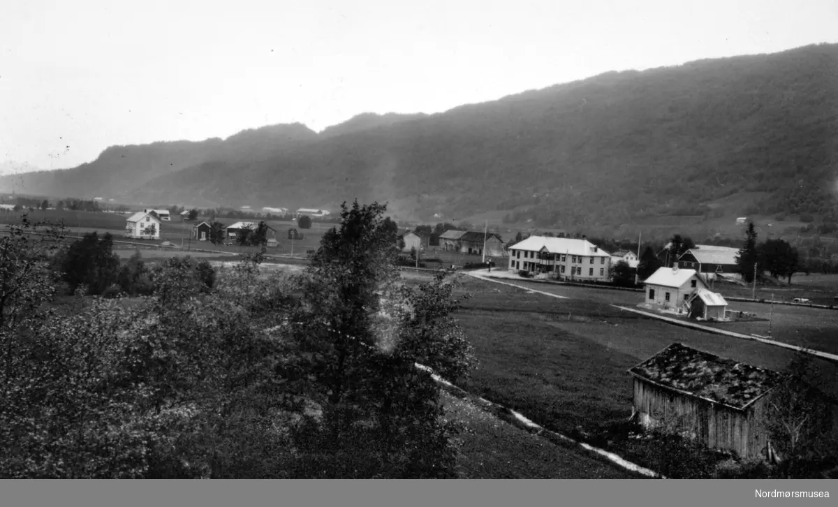 Parti fra Surnadal kommune, hvor vi ser fra deler av bygda i forgrunnen, med fjellet like bak. Fotograf er Georg Sverdrup, og datering er 1936. Fra Nordmøre Museums fotosamlinger.
