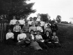 Gruppefoto av tyve kvinner samlet på landtur, med to på førs