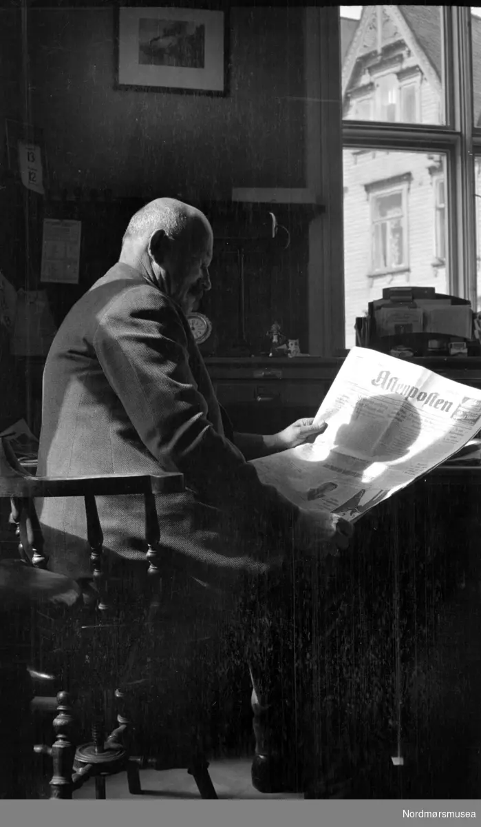 Portrett av Georg Sverdrup som sitter og leser avisen Aftenposten, trolig på kontoret sitt. Fra Nordmøre museums fotosamlinger. EFR2015