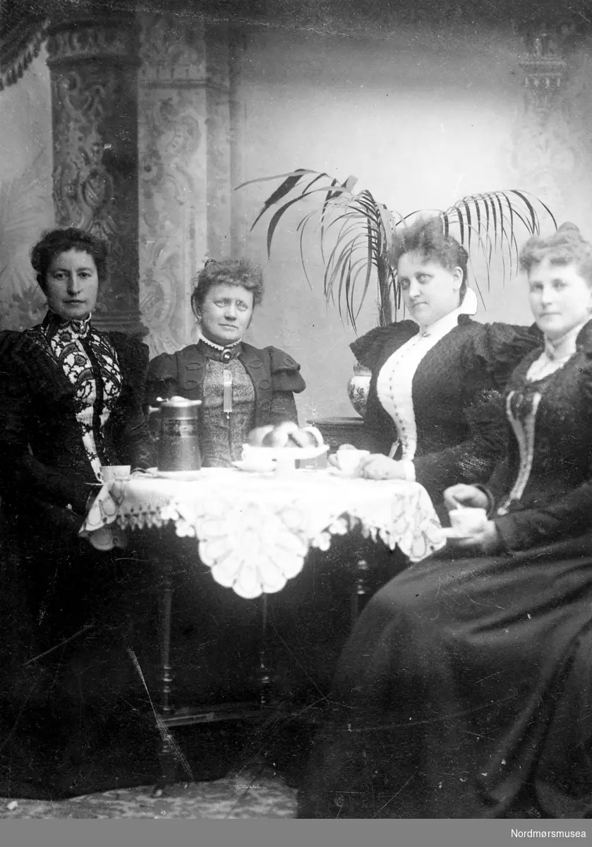 4 myndige oppstasa damer, kvinner poserer med kaffe ca 1880. figursydde stramme kjoler. Fra Nordmøre Museum sin fotosamling.
