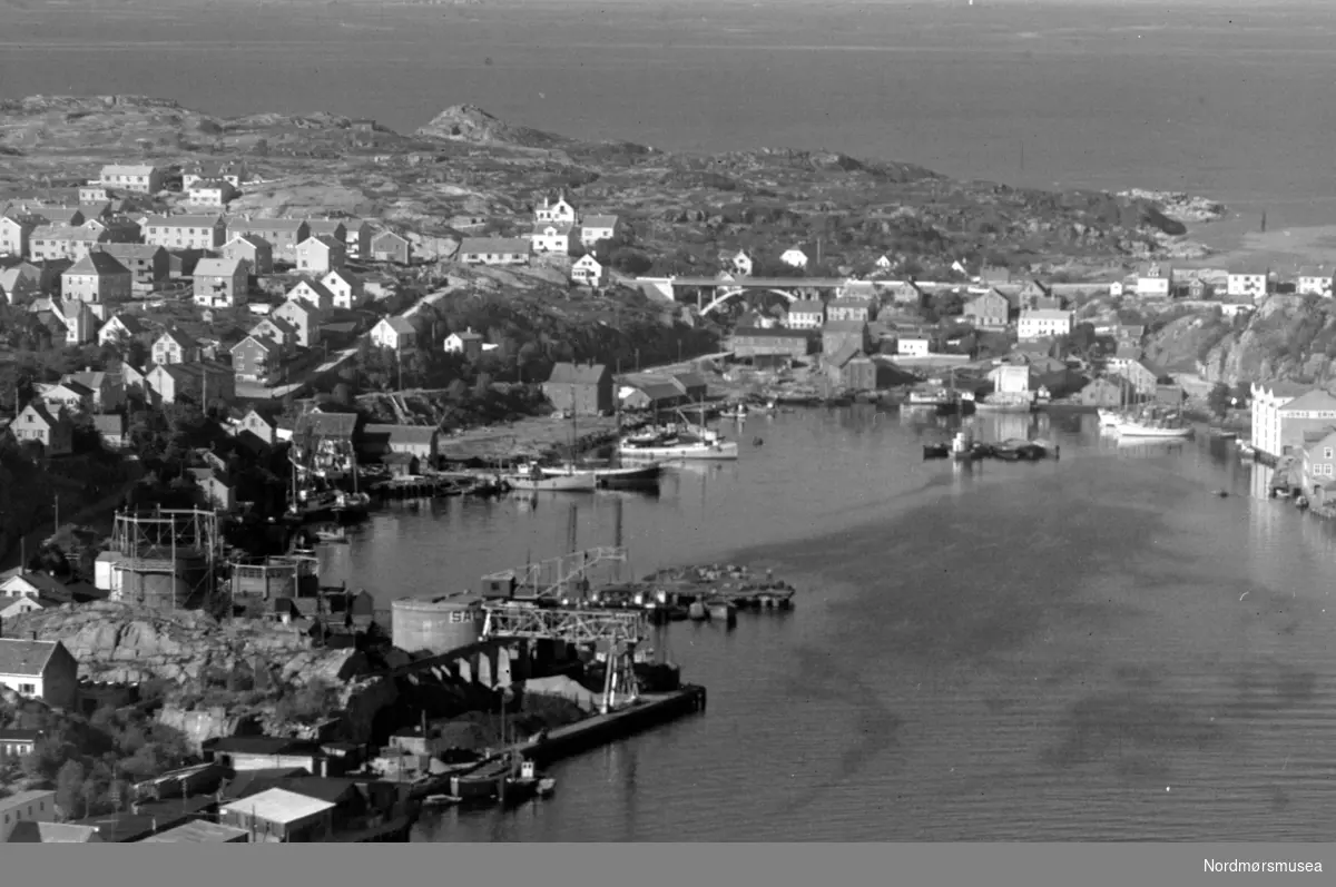 Flyfoto fra Vågen i Kristiansund, med Kirkelandet til venstre og Gomalandet på høyre side. Datering er ukjent, men er trolig fra omkring 1950 til 1960. Kullkrana, Kranaskjæret. Fra Nordmøre museums fotosamlinger.
