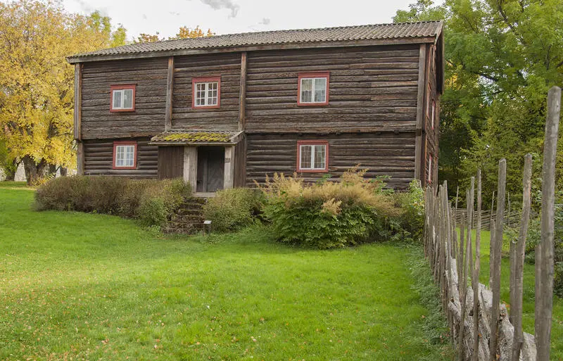 Skøienbygningen er en tømmerbygning i to etasjer med inngang på midten. Grått tømmer, røde planker rundt vinduene. En skigard fører fram mot huset.