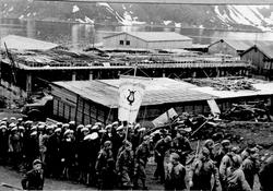 Gjenreisning. Honningsvåg. 17.mai-tog forbi Kolstadbygget (m