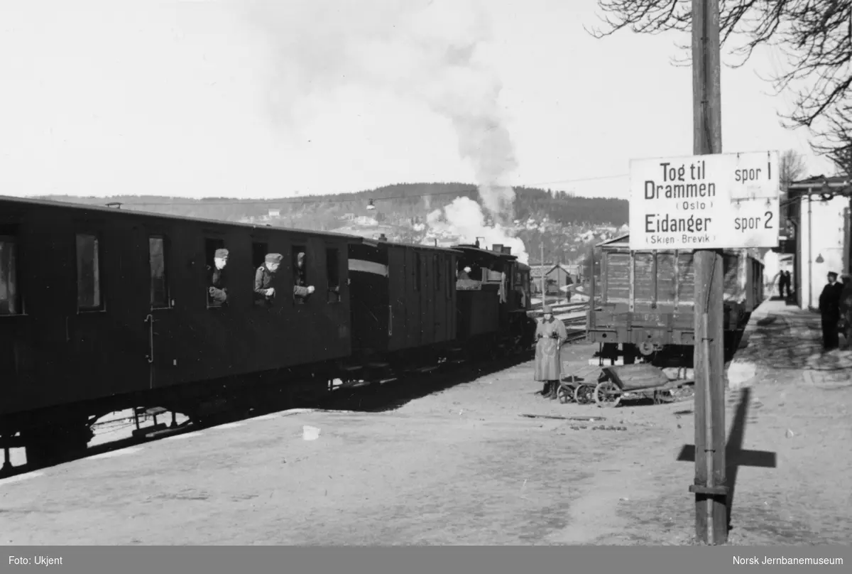 Larvik stasjon med smalsporet tog i spor 1 og skilting, tyske militære