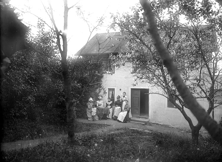 Sex kvinnor och ett barn utanför okänd bostadshus i Växjö, ca 1900.