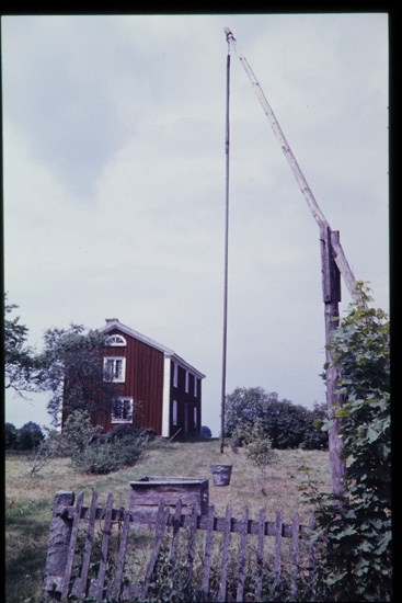 Gård med brunnsanordning av trä. 1958.