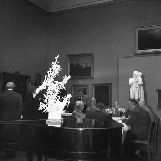 Presentationen av Carl Milles verk "Dacke drömmer" i Konstsalen på Smålands museum.
I förgrunden syns en modell i gips av "Dacke drömmer" på en flygel. Bakom modellen, till höger, skymtar upphovsmannen - skulptören Carl Milles (1875-1955).