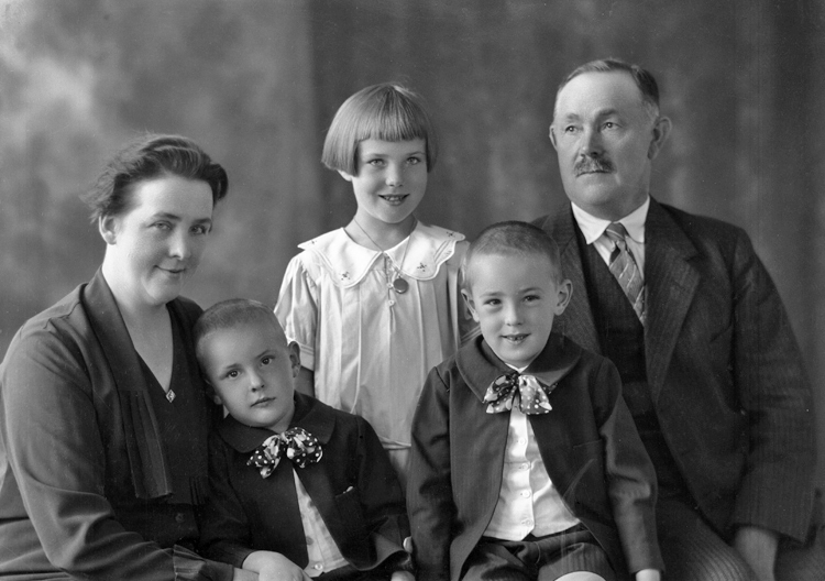 Foto av en okänd familj med tre barn (en flicka och två pojkar).
Ateljéfoto.
