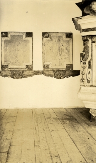 Foto i ett kyrkrum på två nummertavlor och en kamin.