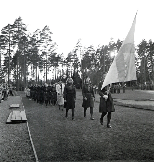 Svenska Flaggans Dag, 6/6 1942. 
Växjö Flickscoutkår paraderar förbi hedersläktaren, med flagga
i täten.