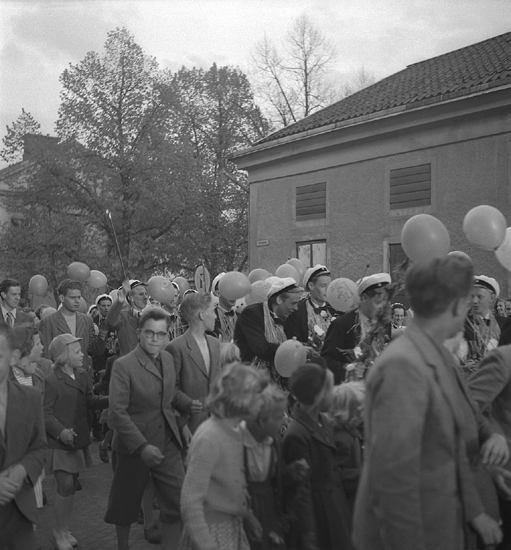 Studenterna andra dagen, 1952. 
Studenter, anhöriga m.fl. tågar upp längs Storgatan mot Stortorget. 
I bakgrunden skymtar allén längs Linnégatan och Gamla Flickskolans
hus.