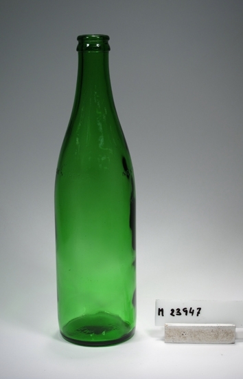 Flaska från Hammar glasbruk.
Färg: Grönfärgat klarglas.
Mått: Ovan angivna mått avser bottendiameter.
Märkning i botten och på bröstet. Se "Signering, märkning" 1 och 2 ovan.
Inskrivet i huvudkatalogen 1977.
Funktion: Flaska