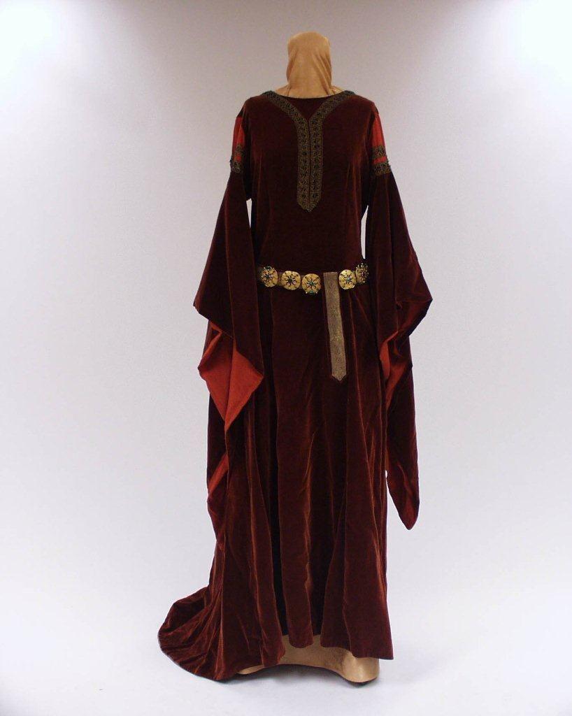 Kostyme Kirsten Flagstad i rollen som Isolde i Tristan og Isolde. En rød kjole i middelalderstil med lange ermer og gullbelte rundt livet.
