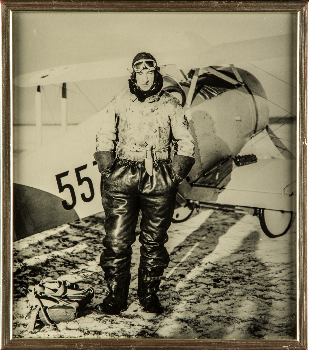 Porträtt. F 5:s förste chef kapten Arvid Flory i flygdräkt framför flygplan Ö 1 Tummelisa 1930. Inramat foto.