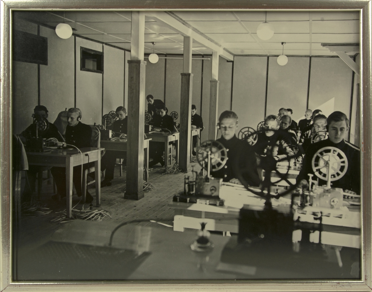 Signaltjänst och telegrafering på F 5 i Ljungbyhed. Värnpliktiga elever övar telegrafering, 1937. Inramat foto.
