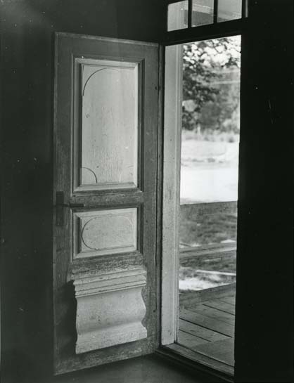 En öppen dörr med speglar, fotograferad inifrån huset.