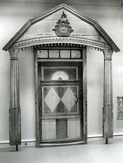 Gaveln av en förstukvist samt en dekorerad dörr vid Ljusdalsbygdens museum.