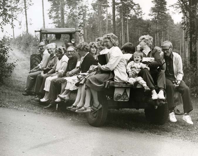 En grupp människor åker på ett lastbilsflak.