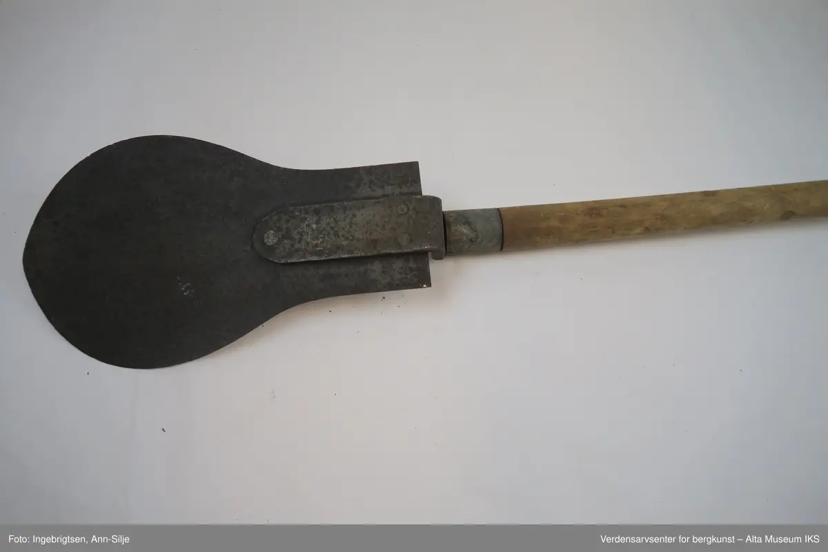 Form: Spaden har pære-formet blad med skaft i tre. Håndtaket er i metall og tre-