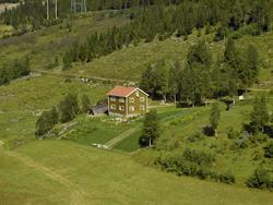 Borgheim. Kulturlandskap med rød-brunt bolighus, grønsakhage