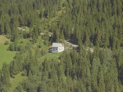 Granly. Hvit enoghalvetasjes privatbolig, flaggstang i front