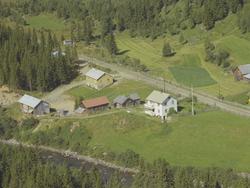 Borgemoen. Hvitt privathus med noe dyrket mark rundt. Hage m