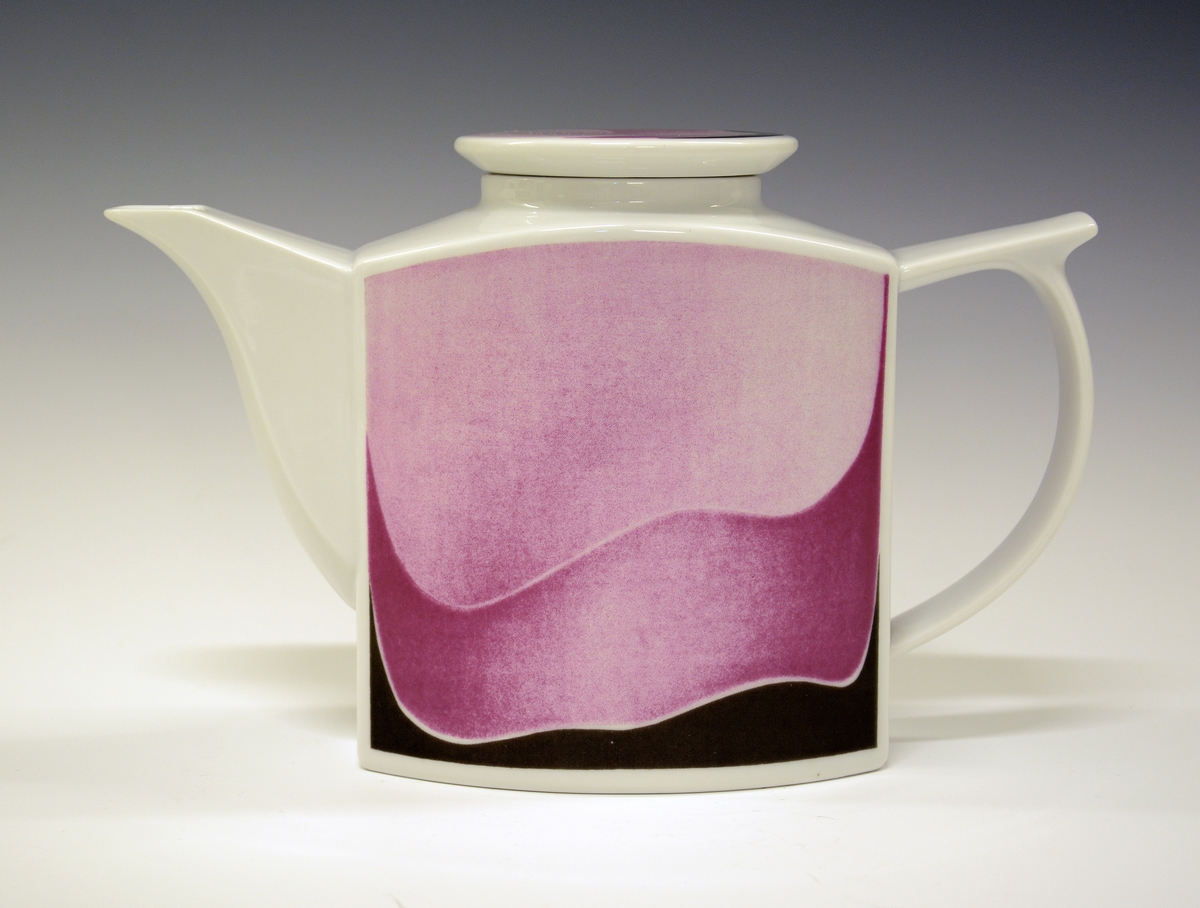 Kaffekanne med lokk, av porselen. Hvit glasur. Lys rosa, mørsk rosa og sort non-figurativ trykkdekor.
Design: Leif Helge Enger.
Modell: Formel