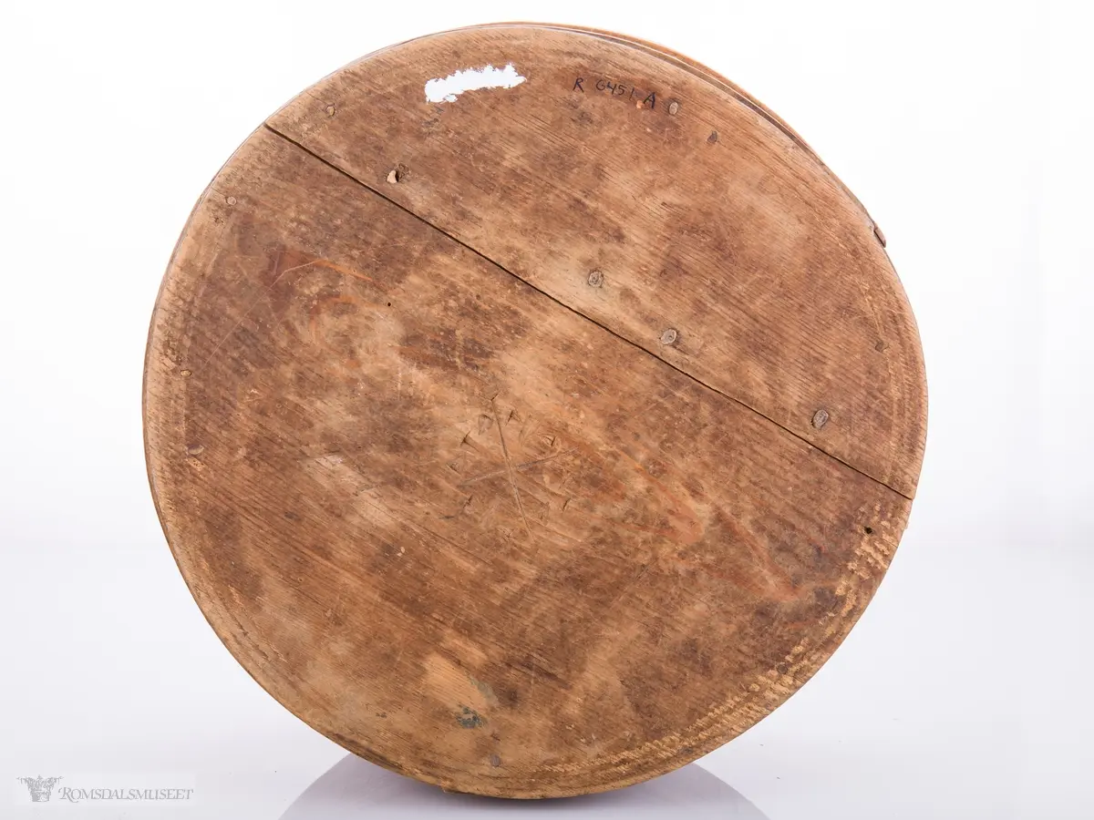 Eit kvistmønster/bregner på lokk. Skravert kryss- mønster langs trosken. Rosett av spetter i bunnen.