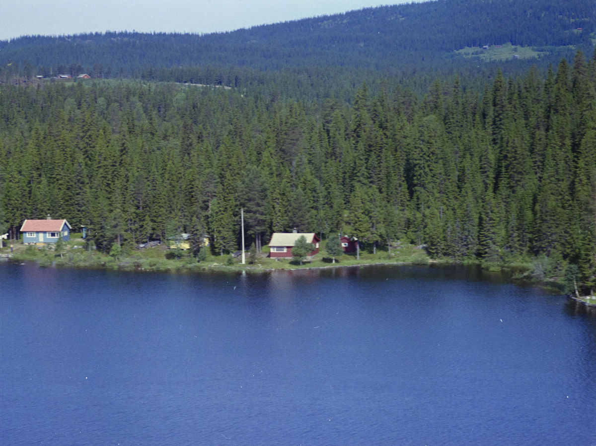 Nord Mesna. Den røde hytta er Olaus Nilsengs hytte. Den blå hytta er Gudbrandsens hytte, vann, vatn, innsjø, skog, bygninger, hytter,