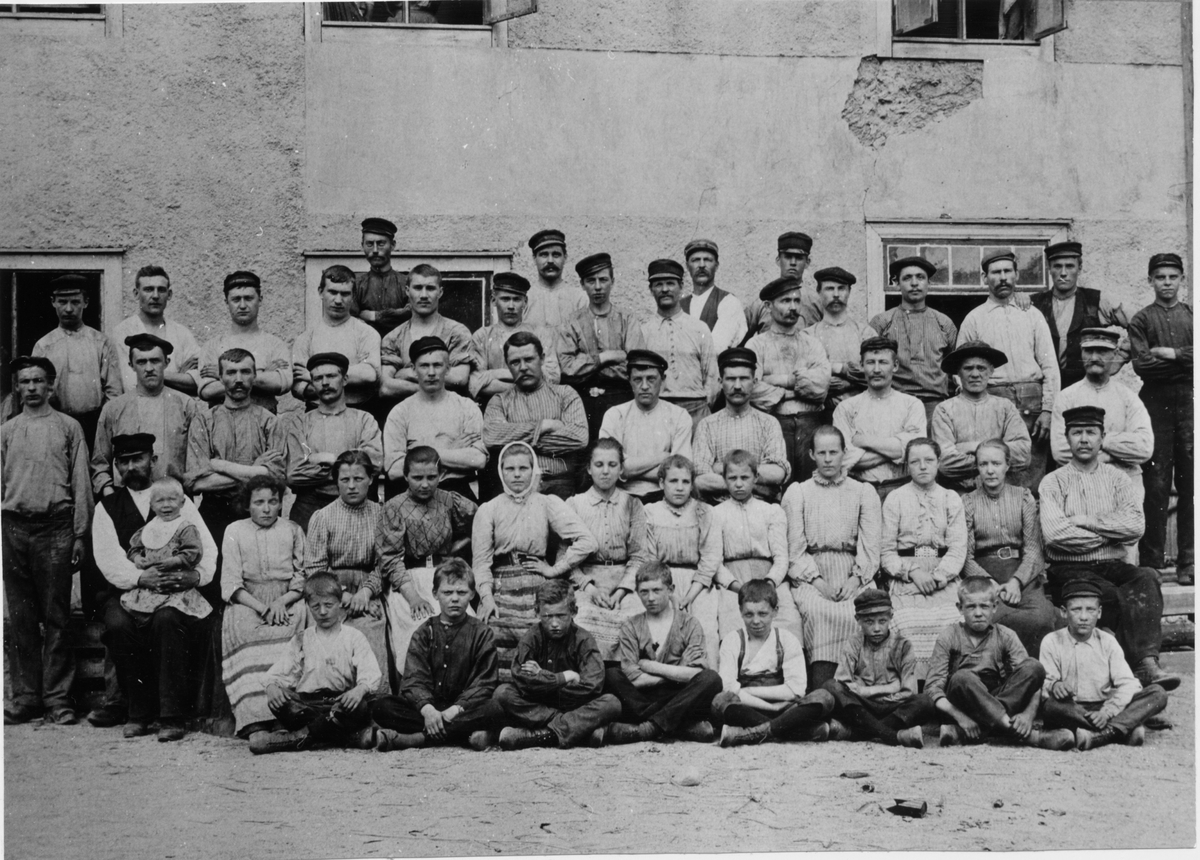 Arbetare vid Gefle glasbruk.
Som nummer två från vänster i översta raden syns buteljuppläggaren August Johannesson.
Flickorna på andra raden nerifrån arbetade som inbärare.
Fotografi från 1890-talet
