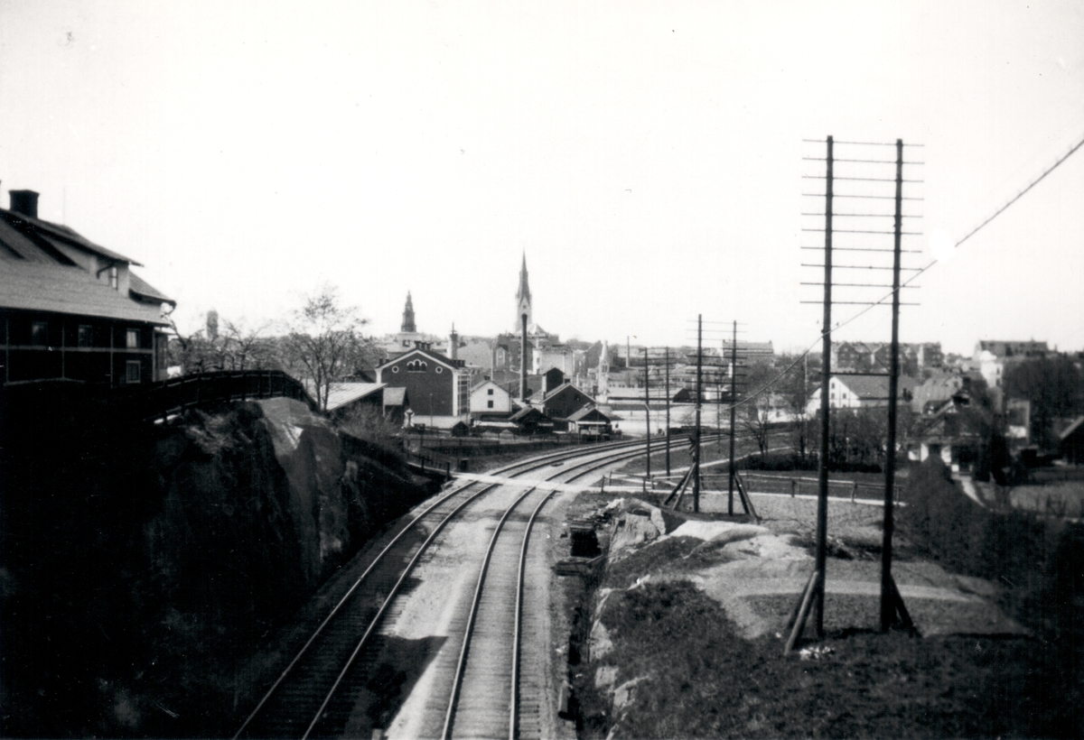 Motiv av järnvägen sedd västerut. Gatan som korsar järnvägen är Gumpekullavägen. Berget till vänster är en del av Ladugårdsbacke som stod i förbindelse med staden genom Stångebro.